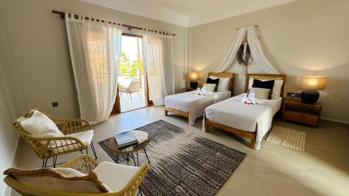 a hotel room with two beds and a living room at Kaskazi Hotel Zanzibar in Jambiani