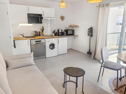 un salon avec un canapé et une cuisine dans l'établissement Séjour Central Cavalaire sur Mer - Élégance & Confort, à Cavalaire-sur-Mer