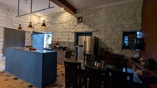 a large kitchen with a counter and a refrigerator at The Ark Farms in Denkanikottai