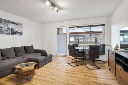 a living room with a couch and a table at 24-7 Living - Lüdinghausen Apartments in Lüdinghausen
