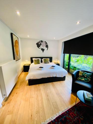 a bedroom with a bed and a chair in it at Casa Tilleghem in Bruges