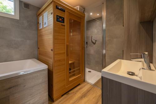 DoornspijkにあるVakantiehuis Veluws Genieten met whirlpool en saunaのシャワーと洗面台付きのバスルーム