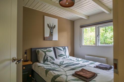 DoornspijkにあるVakantiehuis Veluws Genieten met whirlpool en saunaのベッドルーム1室(鹿の絵が描かれたベッド1台付)