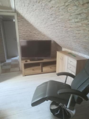 a living room with a chair and a television at Fitness Pension in Sulingen