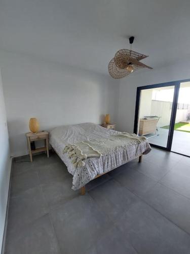 Cette chambre blanche comprend un lit et un miroir. dans l'établissement Bella Vita Garancia Grand T3 Neuf avec piscine à Porticcio, à Grosseto-Prugna