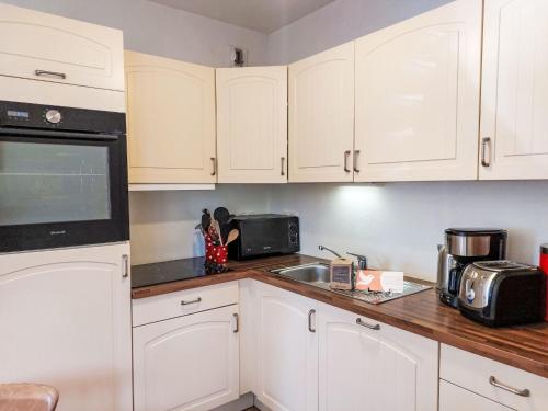 une cuisine avec des armoires blanches et un évier dans l'établissement Apartment Domaine de Crespin by Interhome, à Saint-Gervais-les-Bains