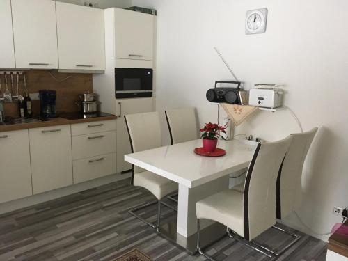 a kitchen with a white table and chairs at Moderne Ferienwohnung am Wald in Siegsdorf