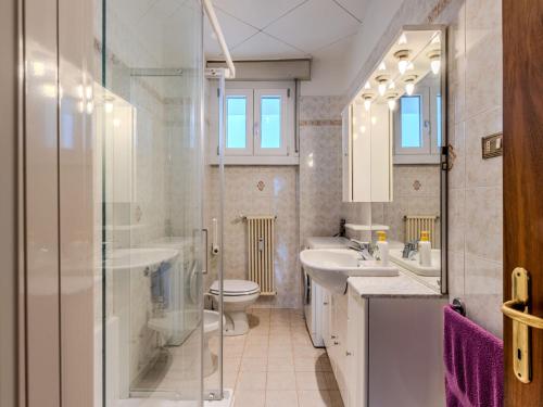 a bathroom with two sinks a toilet and a shower at Apartment SunnyLake by Interhome in Riva del Garda