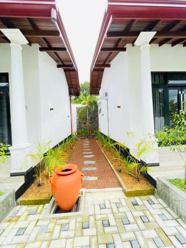 an orange vase sitting in front of a building at Thara Inn Villa in Dickwella