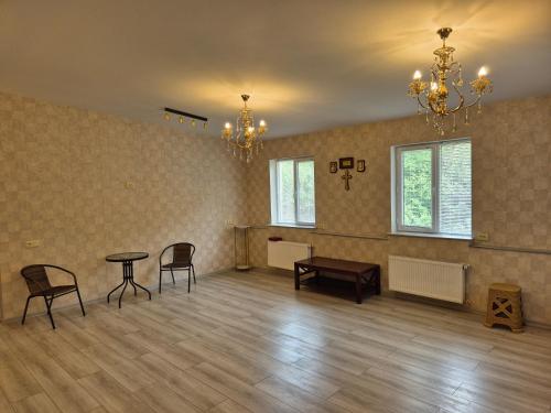 an empty room with chairs and a table and a chandelier at Babilina Hostel & Campsite in Navenakhevi