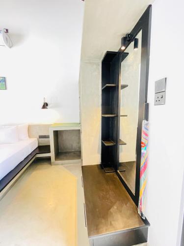 an empty room with a bed and a refrigerator at Thara Inn Villa in Dickwella