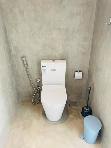 a bathroom with a white toilet in a room at Thara Inn Villa in Dickwella