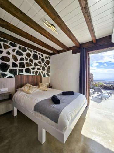 a bedroom with a bed and a large window at La Cabaña Del Sol in La Asomada