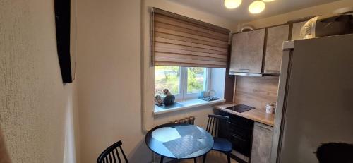 a small kitchen with a table and a window at Riga Ziepniekkalns Apartment in Rīga