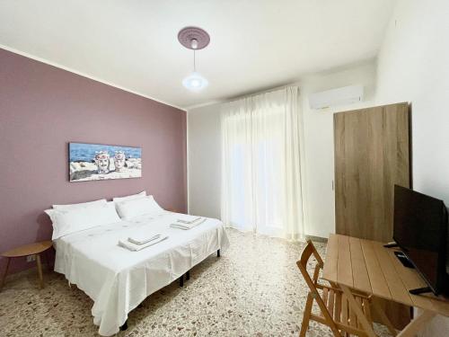 una camera da letto con un letto, una tv e un tavolo di ViLoKa Sicilian Guest House a Calatafimi