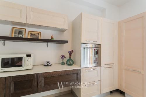 a kitchen with white cabinets and a microwave at Wanderlust Experience La Casetta in Bitonto