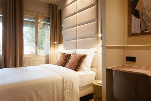 une chambre avec un lit blanc et une fenêtre dans l'établissement Versailles Suite - Duke Housing, à Paris