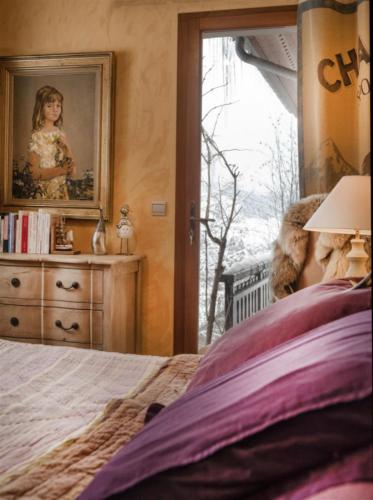 une chambre avec un lit et un tableau au mur dans l'établissement Chalet l'Orée du Bois, à Autrans