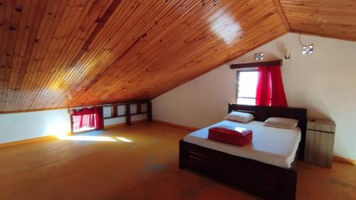 a attic bedroom with a bed and a window at Bemaso in Toliara