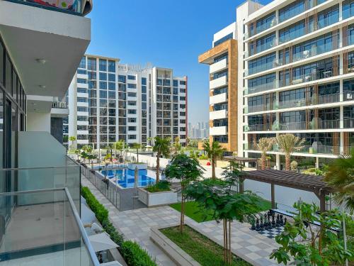 an apartment balcony with a view of a pool and buildings at Royalton - Serene Studio Apt in the Heart of Meydan District in Dubai