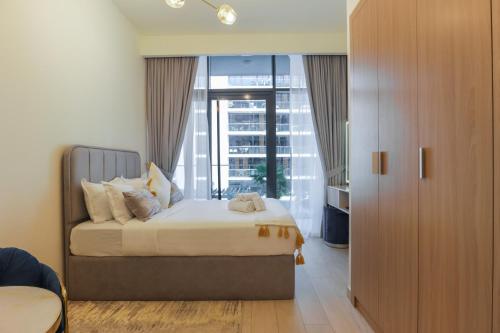 a bedroom with a bed and a large window at Royalton - Serene Studio Apt in the Heart of Meydan District in Dubai