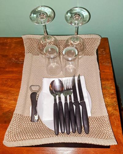 a table with a plate with utensils and wine glasses at Casa Verde Río in Rio de Janeiro