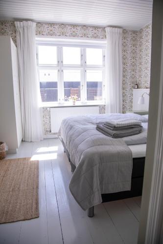 a bedroom with a bed and a large window at Kallehavegaard Badehotel in Løkken