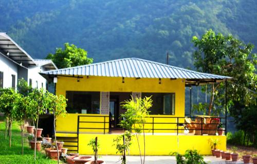 a yellow house with a fence in front of it at ISOL Nature Resort in Rishīkesh
