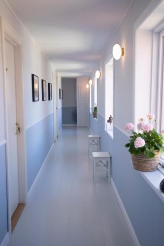 a hallway with blue and white walls and white floors at Kallehavegaard Badehotel in Løkken