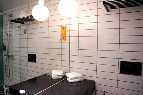 a bathroom with a sink and white tiled walls at Comfort Hotel Norrköping in Norrköping