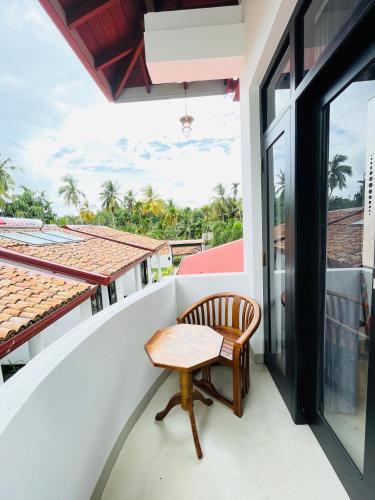 a chair on the balcony of a house at Thara Inn Villa in Dickwella