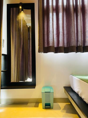 a room with a bed and a mirror and a window at Thara Inn Villa in Dickwella