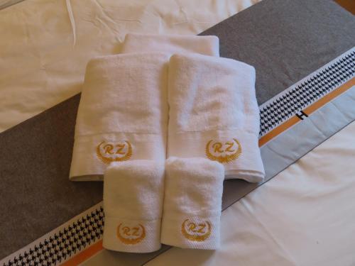 two white towels sitting on top of a bed at Chambre deux personnes avec salle de bain privative in Bondy
