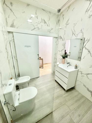 a bathroom with a toilet and a sink at Apartamentos Bobal Requena in Requena