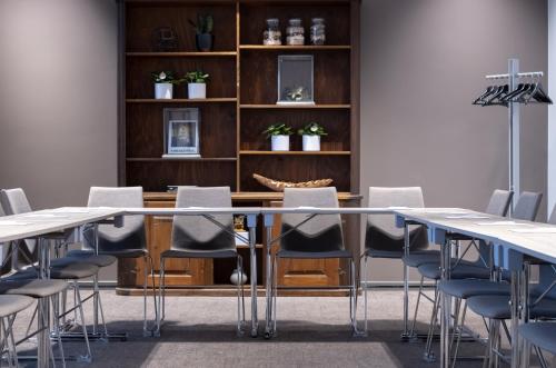 a conference room with tables and chairs and a book shelf at Comfort Hotel Norrköping in Norrköping