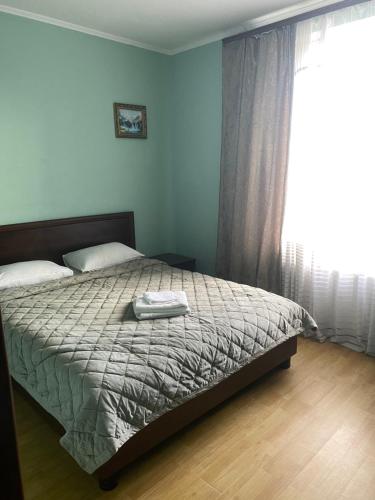 a bedroom with a bed and a large window at Apartments in Umanʼ