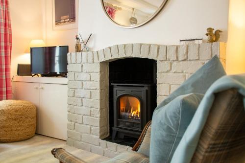 a brick fireplace in a living room with a fire place at Ty Hydref in Beaumaris