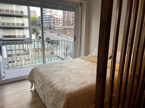a bedroom with a bed and a large window at Relax Guemes in Mar del Plata