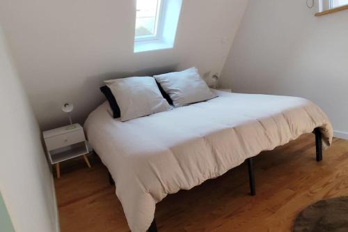 a bed with two pillows on it in a room at Belle petite maison de 70m2 in Neuwiller-lès-Saverne