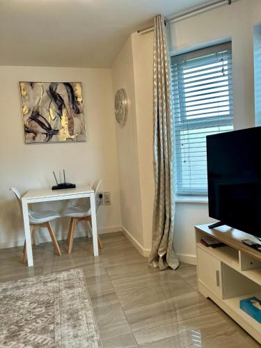 a living room with a white table and a television at Modern 2 Bed Apartment With Free Parking And Netflix in Dawley