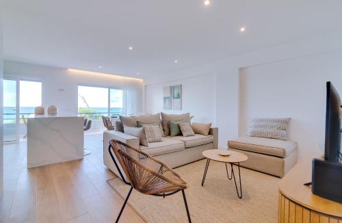 a living room with a couch and a table at Apartamento Gaivota frente-mar in Quarteira