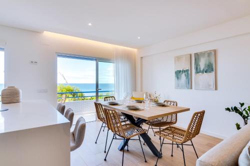 a kitchen and dining room with a table and chairs at Apartamento Gaivota frente-mar in Quarteira