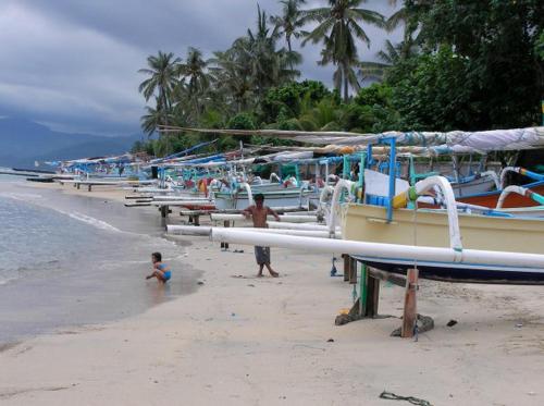 a group of boats on a beach with people on it at Naradas Mushroom Beach in Nusa Lembongan