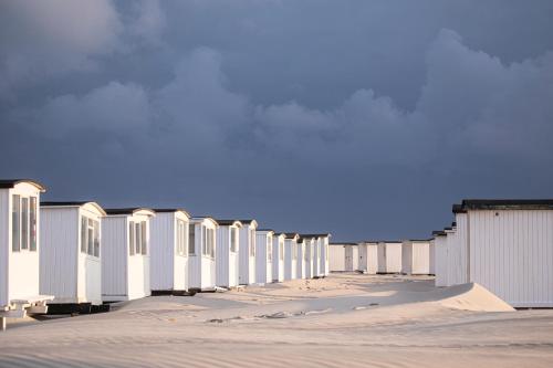 a row of white buildings on the side of a road at Kallehavegaard Badehotel in Løkken