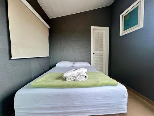 a bedroom with a bed with towels on it at Espaço Verano - Suítes in Niterói