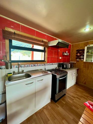 a kitchen with a sink and a stove at Cabañas Puntocom in Puerto Aisén