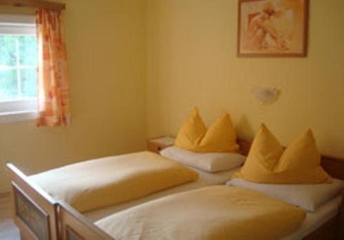 a bedroom with two beds with yellow pillows at Gästehaus-Pension Bendler in Kirchdorf in Tirol