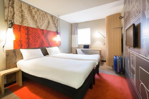 a hotel room with a bed and a dresser at ibis London Docklands Canary Wharf in London