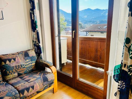 a living room with a chair and a sliding glass door at Haus Winkl 55 in Mariatal