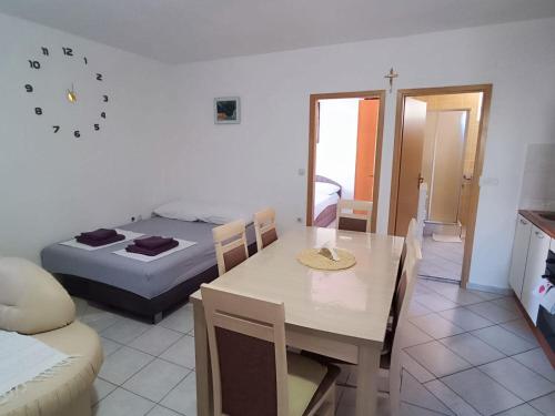 pokój ze stołem i łóżkiem oraz pokój z jadalnią w obiekcie Apartment Kety w Novalji